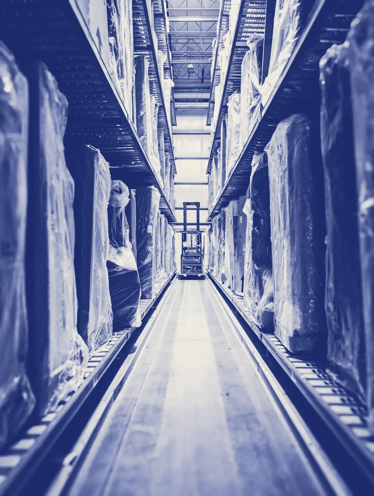 Long warehouse aisle with a forklift at the far end